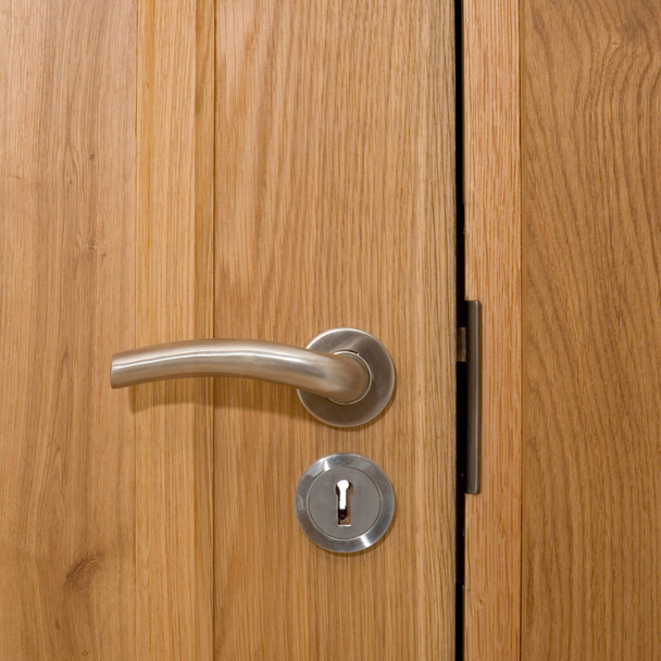 Współczesny uchwyt drzwi na zamkniętych drzwiach z litego drewna - Zdjęcie, obraz