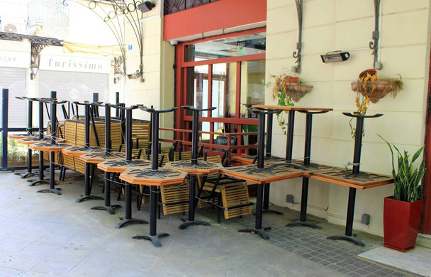 Ateny, Grecja, 6 maja 2020 r. - stoły i krzesła ułożone przed zamkniętą kawiarnią-restauracją podczas zamknięcia Coronavirus. - Zdjęcie, obraz