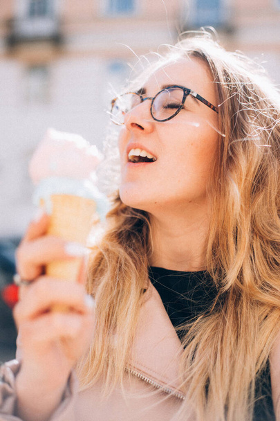 όμορφο κορίτσι τρώει ένα παγωτό σε εξωτερικούς χώρους την άνοιξη - Φωτογραφία, εικόνα
