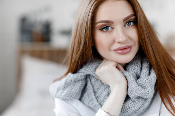 Pretty female with fair hair, dressed casually, looking with satisfaction at camera, being happy. Home shot of good-looking beautiful woman. Nice day in home.Home portrait of a cute girl in a relaxed atmosphere. - Фото, зображення