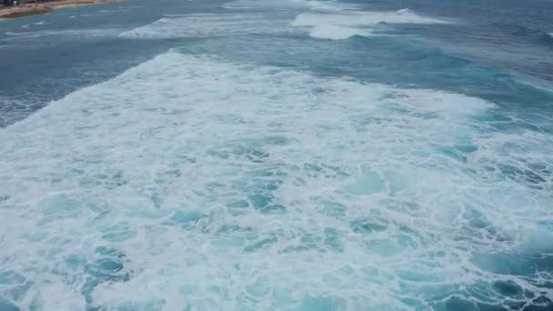 Vue aérienne des vagues puissantes sur l'océan bleu turquoise s'écrasant et moussant
. - Séquence, vidéo