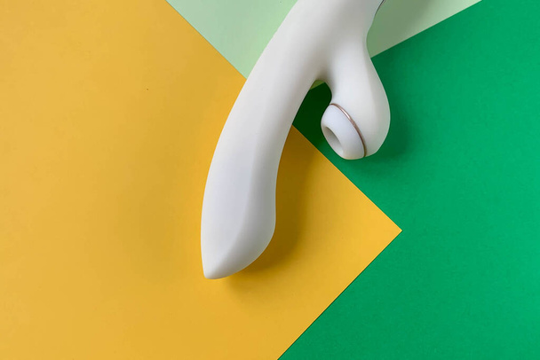 Un sextoy. Vibromasseur blanc sur fond vert / jaune. Utile pour les adultes, sex shop
 - Photo, image