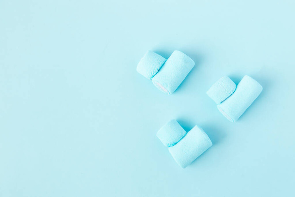 bright blue marshmallows in the shape of a heart on a blue background - Zdjęcie, obraz