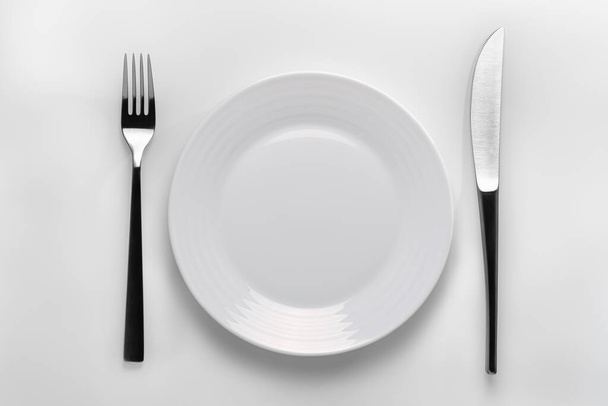 Zbliżenie ustawień stołu z białą tabliczką na białym tle. Aby przedstawić koncepcję zdrowego odżywiania lub ilustracji dla produktu. - Zdjęcie, obraz