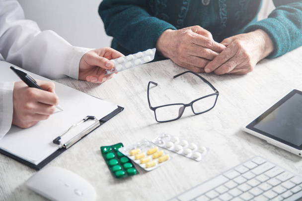 Doctor giving pills to elderly woman. Health, Medicine, Care - Valokuva, kuva