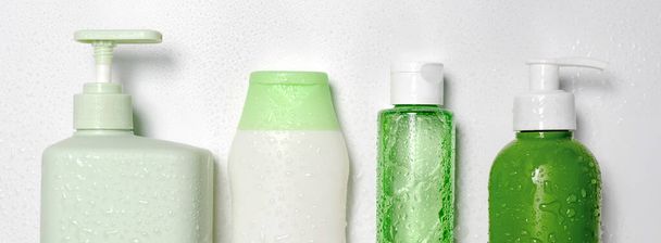 Contenitori di diverse dimensioni e forme per detergente tonico condizionatore tonico, sapone e shampoo su fondo bianco con gocce d'acqua.Prodotti di bellezza biologici naturali, confezione in etichetta bianca, modello di branding
 - Foto, immagini