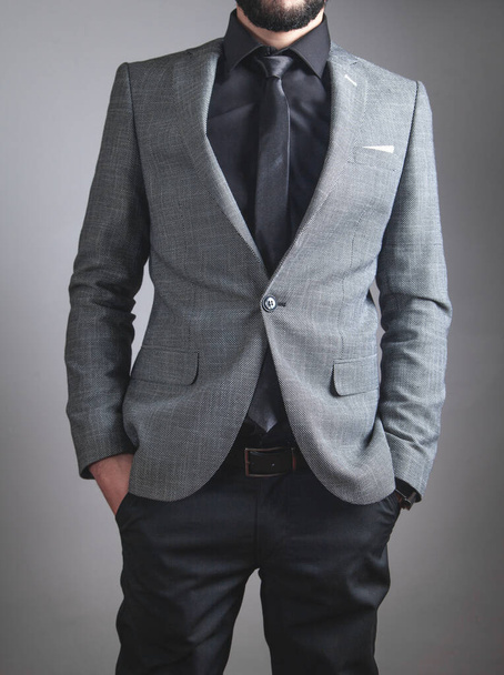 Бизнесмен в черном галстуке и куртке, стоящий в офисе
. - Фото, изображение