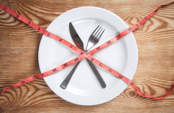 Measuring tape on a white plate. Diet, Health, Weight - Photo, Image