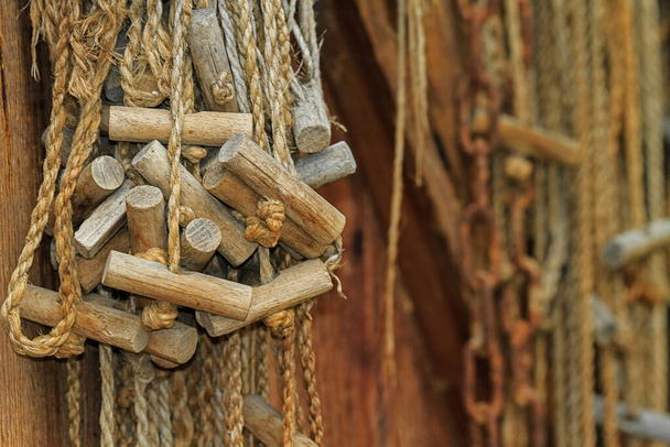 Corde con manici in legno appesi a un muro, forniture per la pesca
 - Foto, immagini