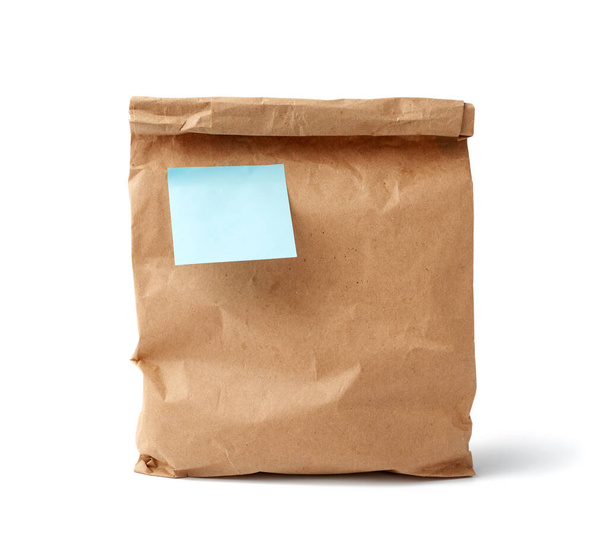 sac jetable en papier plein de papier kraft brun avec un autocollant blanc bleu collant isolé sur fond blanc, concept de rejet de l'emballage en plastique, modèle pour concepteur
 - Photo, image