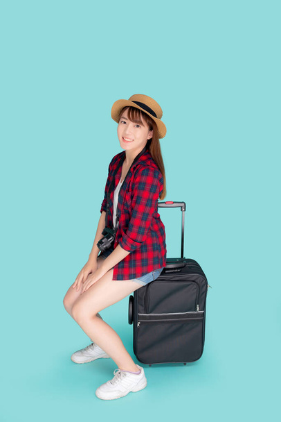 Beautiful portrait young asian woman sitting on luggage smiling and travel summer trip for abroad in vacation, happy asia girl having camera sitting on suitcase for journey with cheerful in holiday. - Фото, зображення