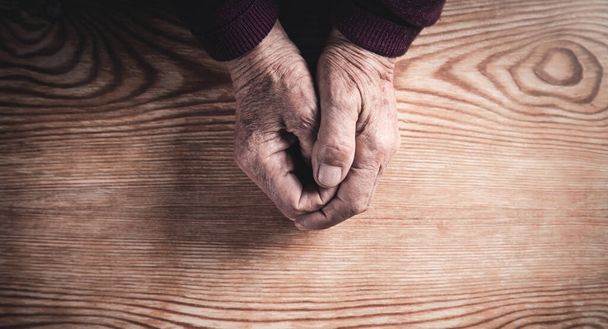 Τα χέρια της ηλικιωμένης γυναίκας που προσεύχεται. Έννοια θρησκείας - Φωτογραφία, εικόνα