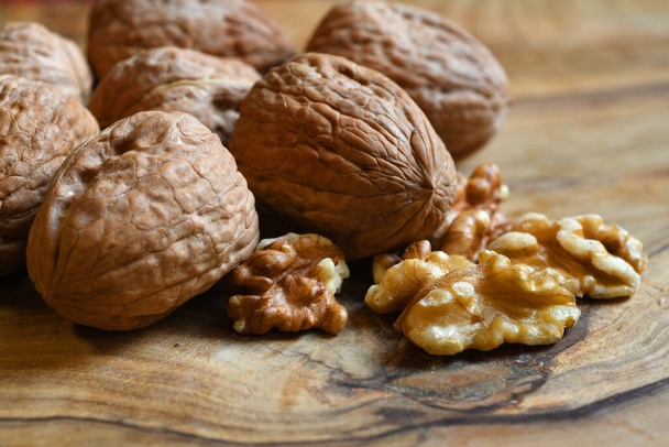 Lähikuva saksanpähkinät puinen tausta. Pähkinä ytimiä oliivipuun puinen maalaismainen pöytä. Terveelliset elintarvikepähkinät
. - Valokuva, kuva