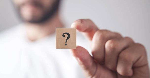 Man showing question mark on wooden cube. - Photo, Image