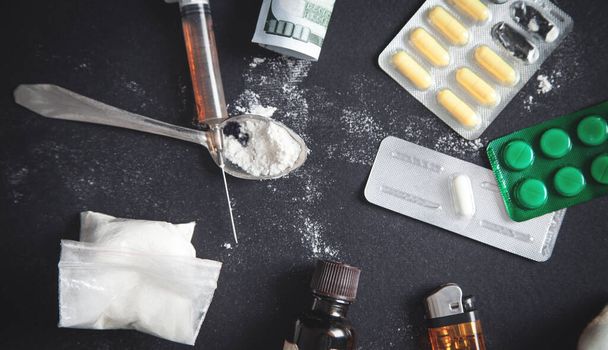 Egy csomag heroin és tabletta. Kábítószerfüggőség  - Fotó, kép