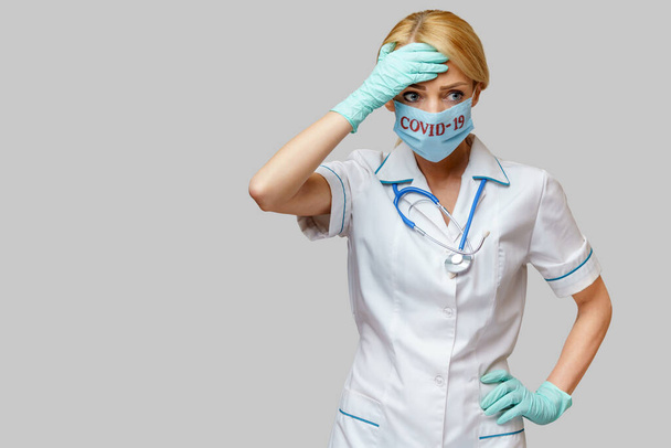 medical doctor nurse woman wearing protective mask and rubber or latex gloves - headache and stress - Fotoğraf, Görsel