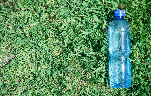 Botella de agua de plástico en la hierba
. - Foto, Imagen