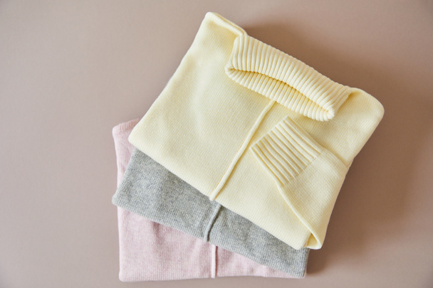 top view of pink, beige and grey knitted soft sweaters - Photo, Image