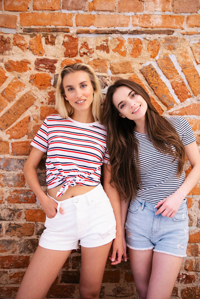 Portrait of two cheerful teenage girls posing to a camera. - Фото, зображення