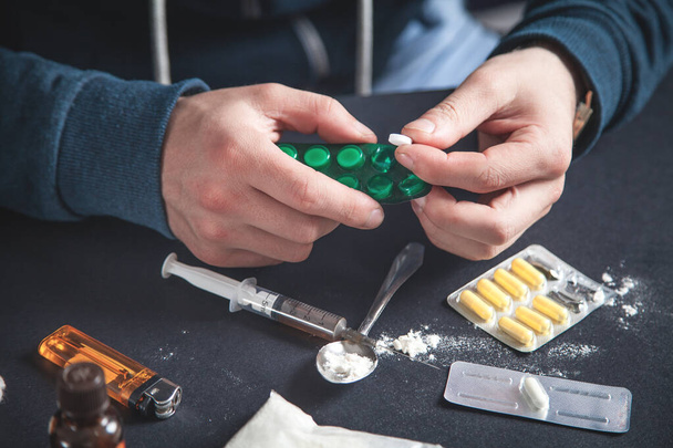 Um viciado em drogas a tomar comprimidos. Toxicodependência
  - Foto, Imagem