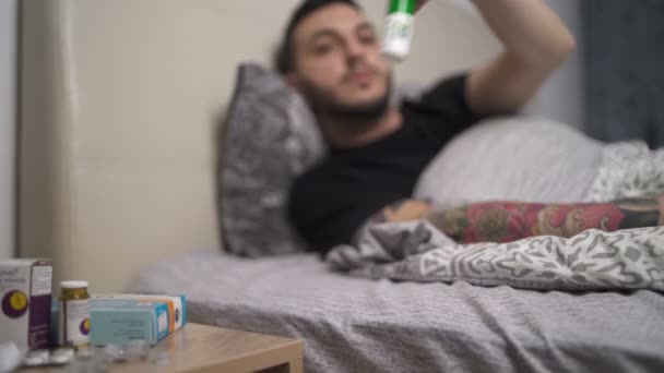 Sick man taking medicines for his sore throat, home isolation - Materiał filmowy, wideo