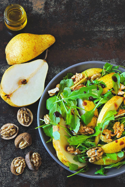 Healthy food bowl. Salad with arugula, pear and walnut. Vegan bowl of colorful salad. Colorful, healthy foods. - Фото, изображение