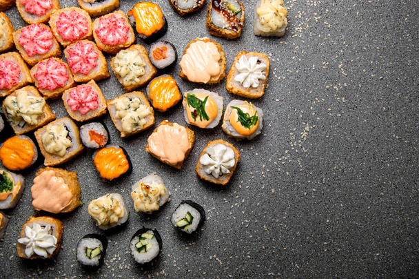 A large set of various rolls and sushi. Hats from the sauce. Baked rolls. Gray background - Foto, Bild
