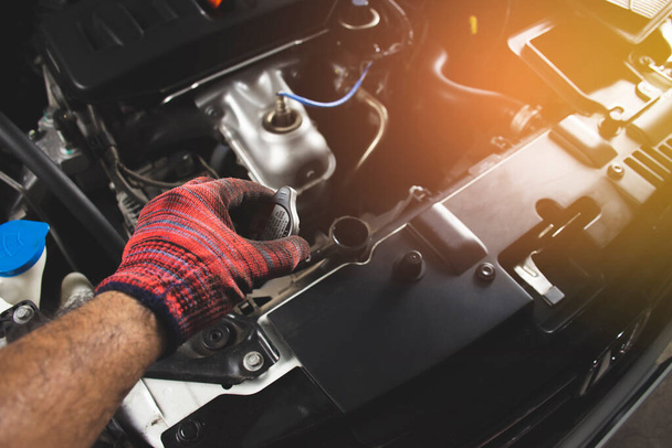 Mechaniker mit rotem Handschuh öffnet Kühlerhaube eines Autos, Kfz-Wartungskonzept. - Foto, Bild