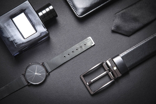 Tie, belt, wristwatch and perfume on the black background. Men accessories - Fotoğraf, Görsel