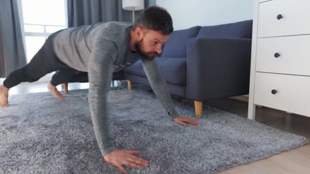 Caucasian man does exercise at home during quarantine due to COVID-19 - Séquence, vidéo