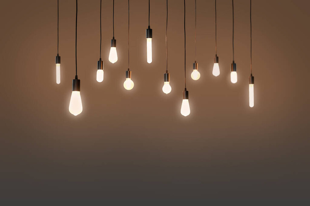 Glühbirnen elektrisch und ein Licht als Konzept Hintergrundfarbe braun - Foto, Bild