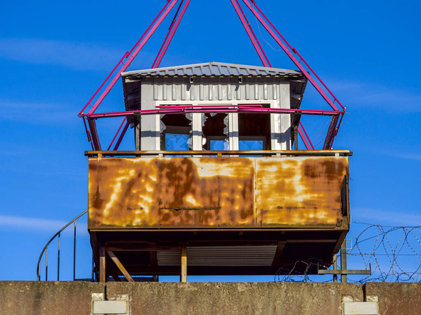 Antigua torre de observación en el abandonado complejo penitenciario ruso soviético. Torre de guardia de la prisión, cerca con alambre de púas.  - Foto, imagen