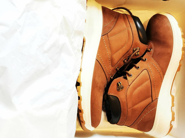 Nouvelles chaussures en cuir marron avec semelles blanches dans une boîte. Achats de vêtements Demi-saison
. - Photo, image