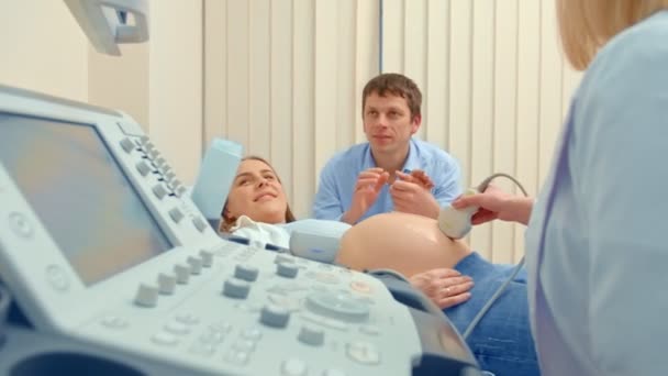 Paar kijken naar echografie scan van baby op tablet pc op bank - Video