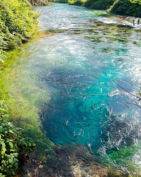 Tiefe Unterwasserhöhle des Gebirgsflusses mit kristallklarem Wasser, das oberirdisch mit schnellem Strom inmitten eines Waldes auftaucht, das blaue Auge der albanischen Berge - Foto, Bild