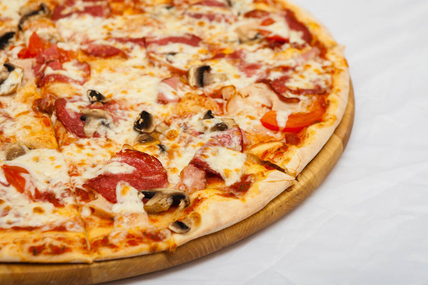 Pizza op een houten plank op een witte achtergrond - Foto, afbeelding
