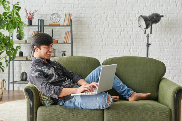 Человек, работающий из дома, ноутбук и слушающий музыку
. - Фото, изображение