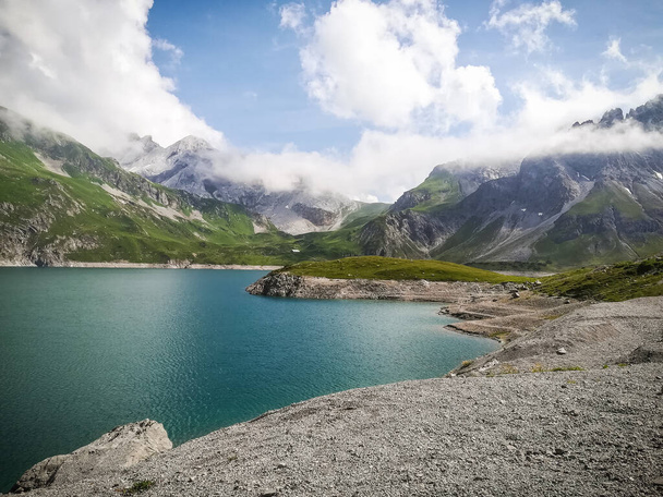 Gran lago de montaña de agua azul soleado, día de verano nublado con alto contraste, espectaculares acantilados de montaña en Austria, Tirol
 - Foto, imagen