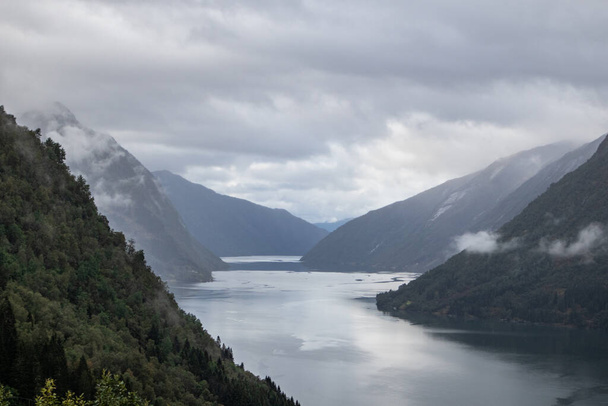 Cold colors Norway fjord scenic foggy heavy clouds landscape with cold water. Dramatic panoramic view in northern summer scandinavia. Travel north background. - Foto, afbeelding