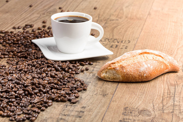Šálek kávy a kávových zrn na dřevěném stole  - Fotografie, Obrázek