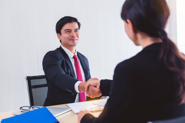 Businessman handshake with customer for dealing contract or greeting. Boss employ worker that he get headhunter of professional businessperson from another company. He get happy when she join the team - Photo, Image
