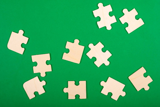 raccogliere puzzle. pezzi di puzzle sparsi su uno sfondo verde
 - Foto, immagini