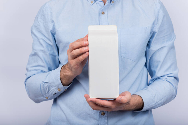 Man holds big pack of milk or juice. Copy space, mock up. - Foto, immagini