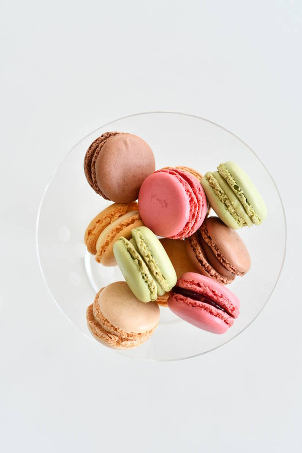 Cake macaron or macaroon on white background, sweet and colorful almond cookies with various pastel colors, vintage look. Different types of macaroons are a delicious dessert. - Photo, Image