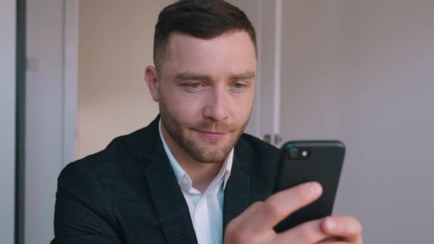 Confident Businessman in Formal Suit Sitting at His Desk in Home Office Using Smartphone, Browsing Through Internet, Social Media. - Záběry, video