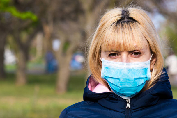 Junge Frau mit Gesichtsmaske auf der Straße. Neuartiges chinesisches Coronavirus-Konzept des Selbstschutzes. - Foto, Bild
