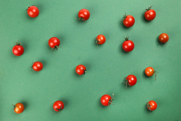 Tomate cherry maduro rojo con tallo sobre papel verde copiar espacio de texto
 - Foto, Imagen