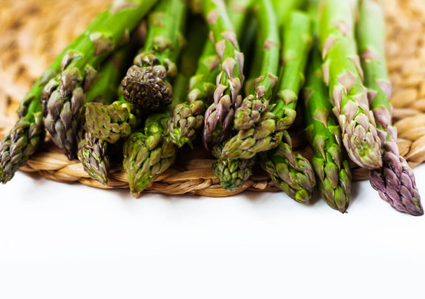 Bunch of fresh raw asparagus on white background, vegetarian concept. Green grass sparrowgrass sticks, food for veggie - Foto, immagini