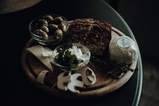 olajbogyó sajt és kenyér a fa tányéron  - Fotó, kép