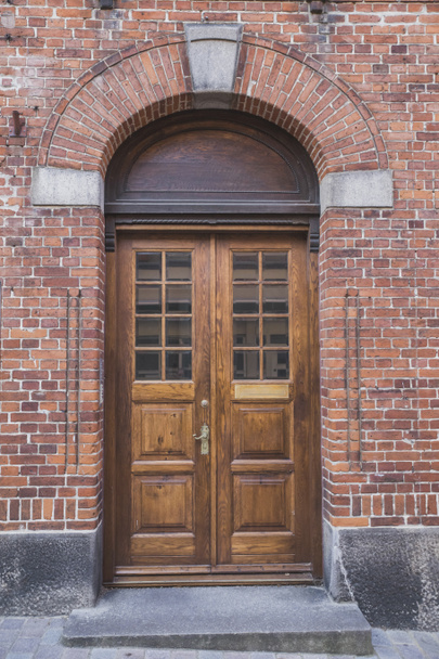 деревянные двери с аркой в старом кирпичном доме
 - Фото, изображение